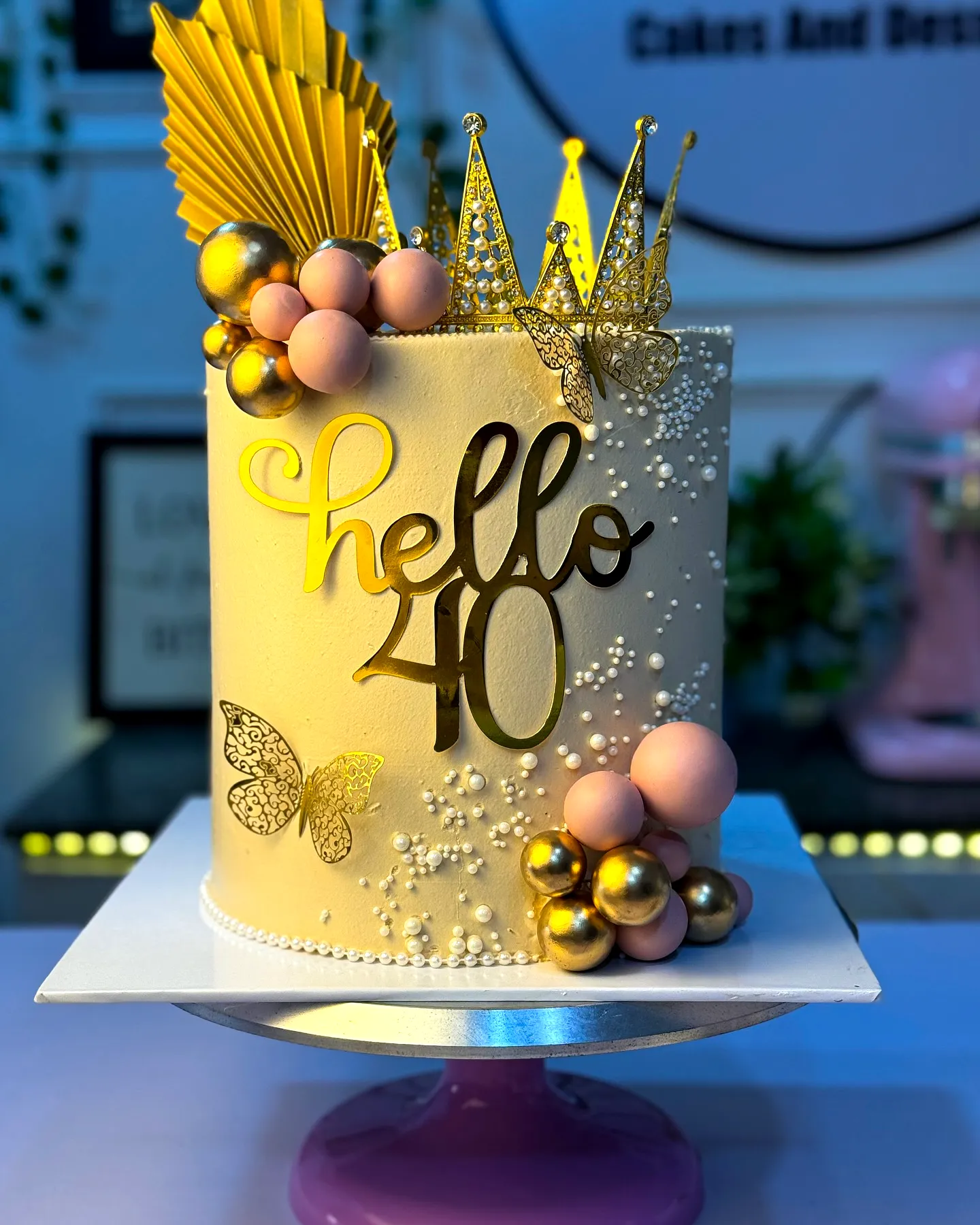 Elegant golden birthday cake design with pastel accents and chic details