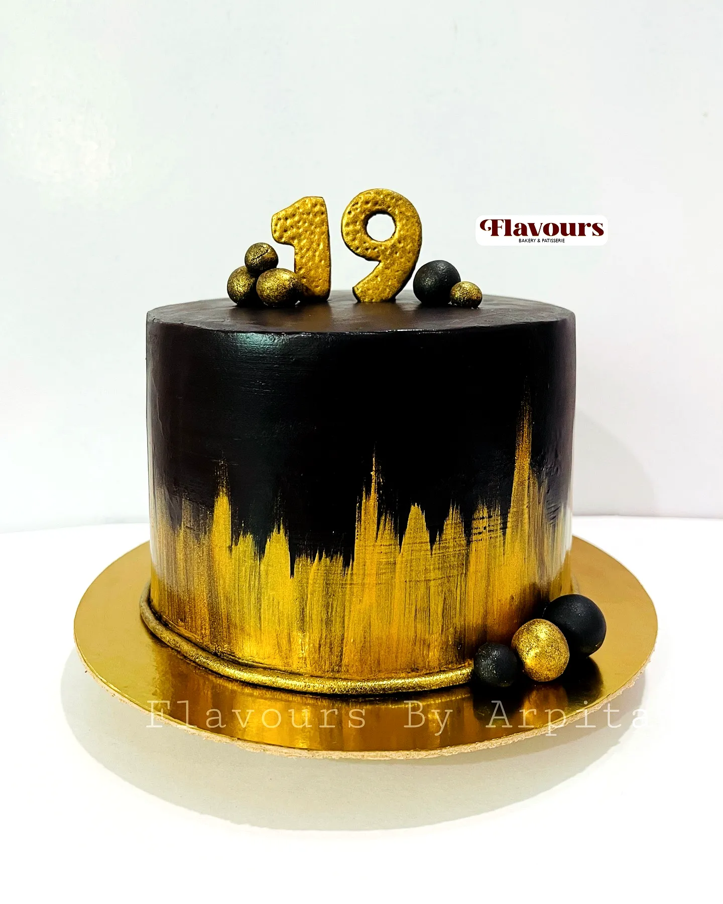 Elegant modern 19th birthday cake with black and gold accents