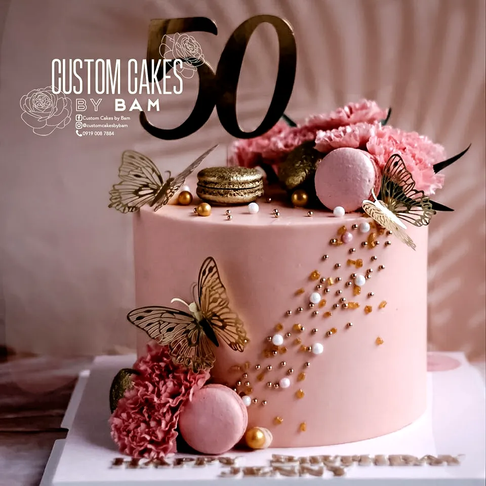 Elegant pastel pink 50th birthday cake for women with floral decorations