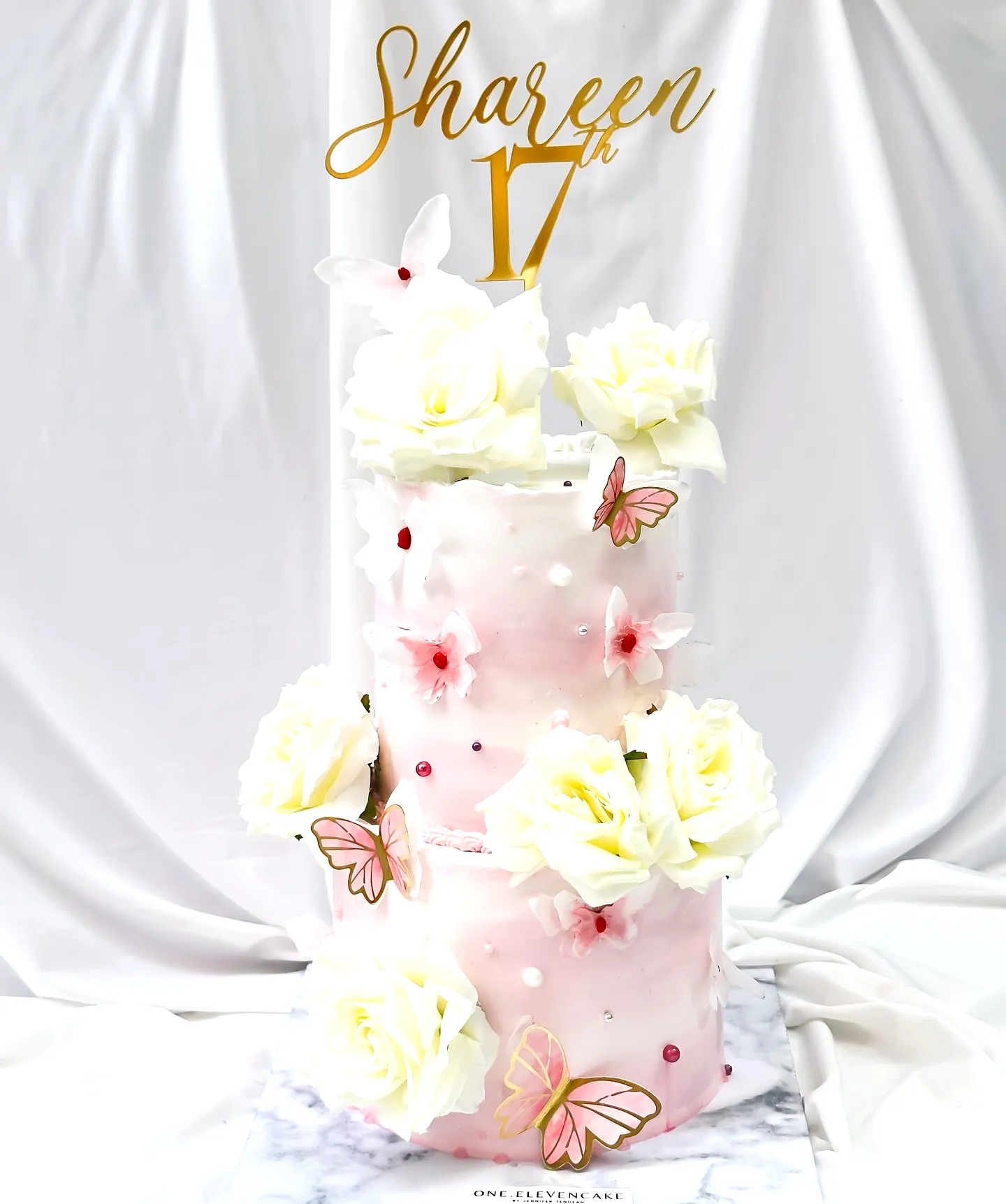 Elegant pink and white 17th birthday cake design with floral accents