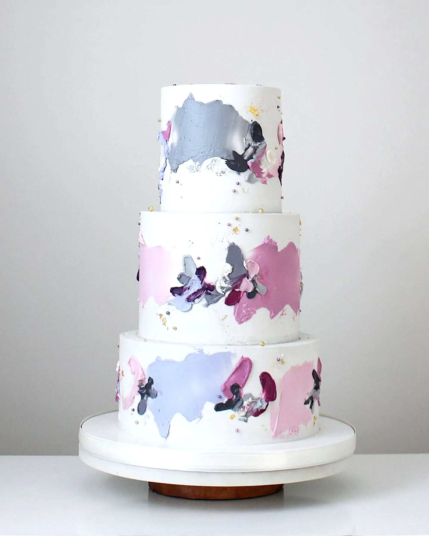 Elegant purple birthday cake design with modern abstract patterns and floral decor