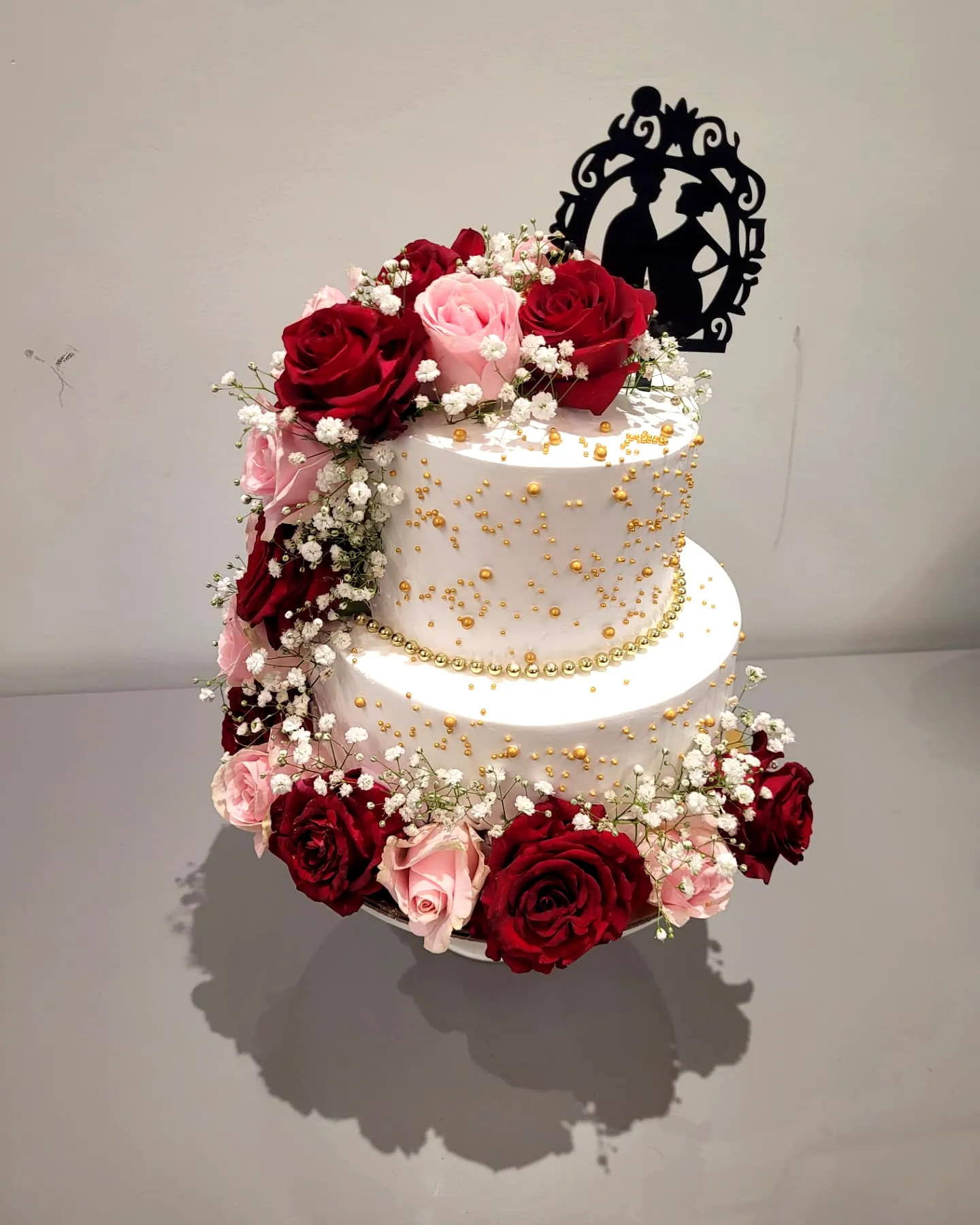 Elegant two-tier round wedding cake with floral accents and gold details