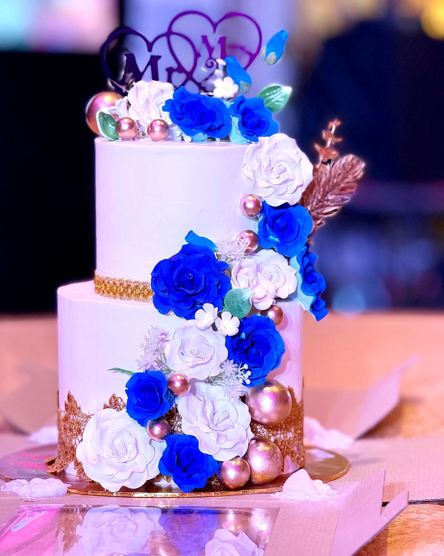 Elegant Two Tier Wedding Cake with Blue Flowers and Golden Accents