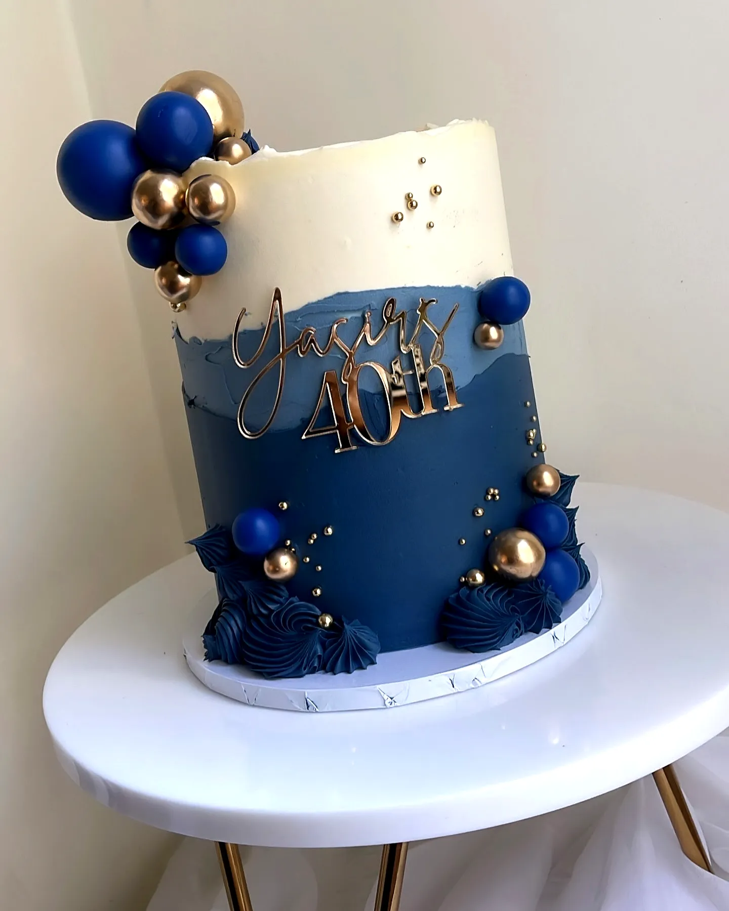 Elegant two-tiered blue and white cake for 40th birthday celebration