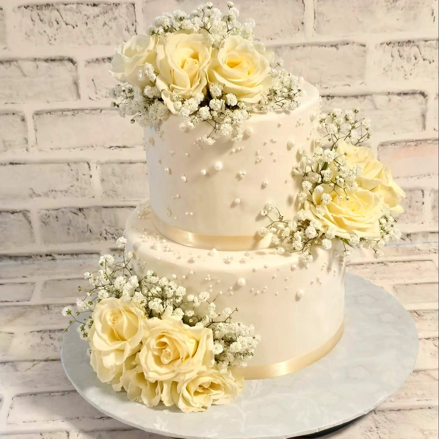 Elegant wedding cake design with delicate pearls and fresh flowers