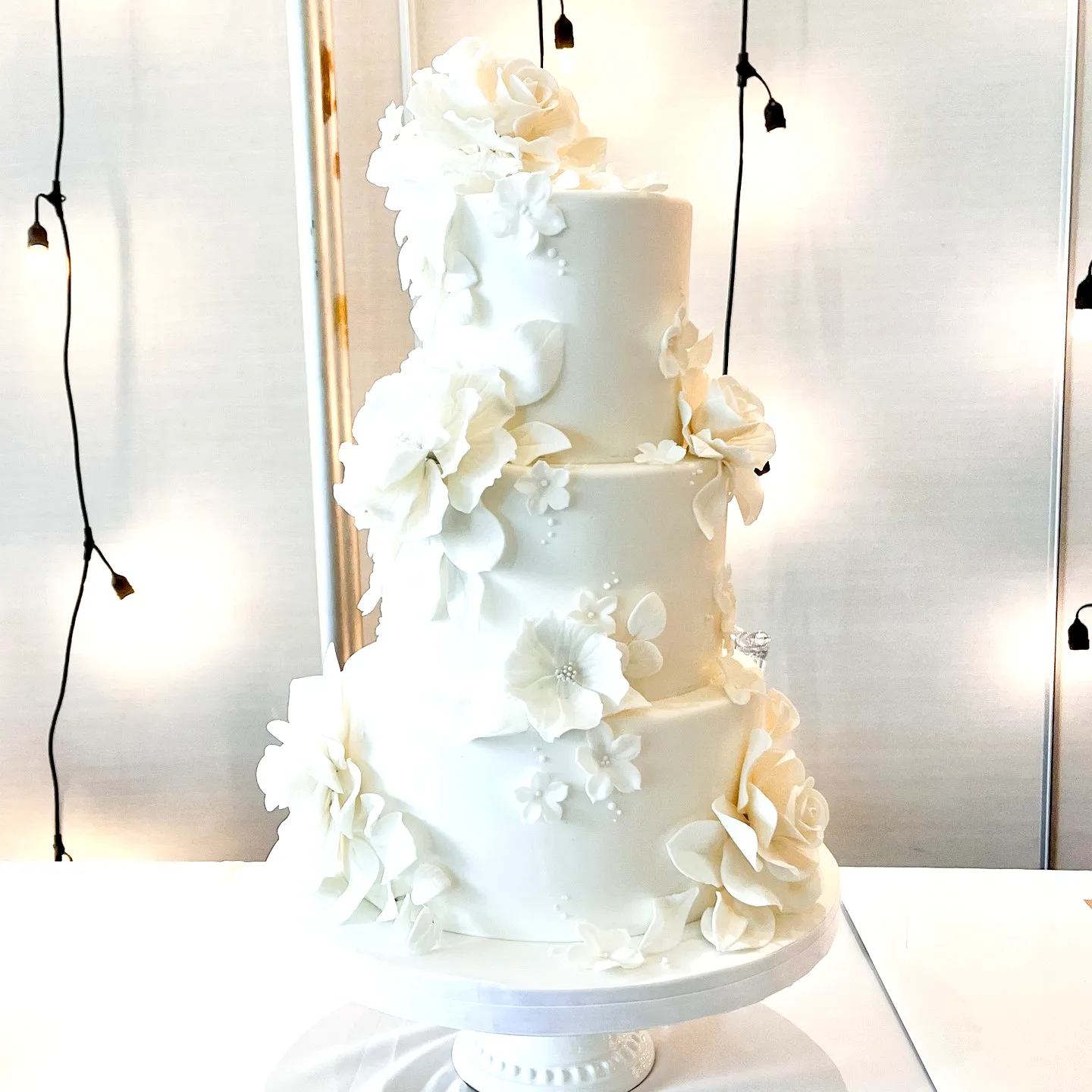 Elegant wedding cake design with intricate sugar flowers and floral patterns