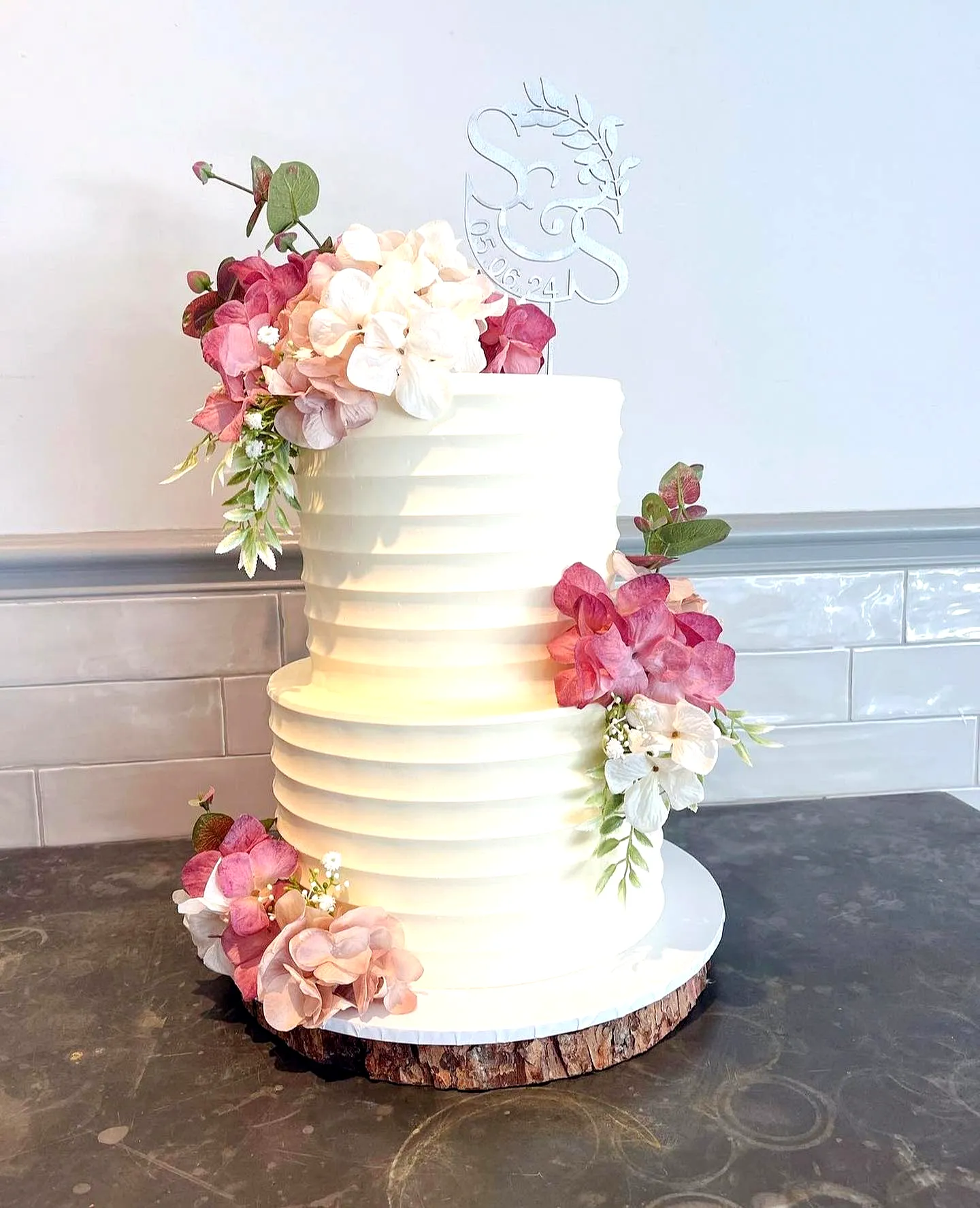 Elegant wedding cake design with semi-naked buttercream and floral accents