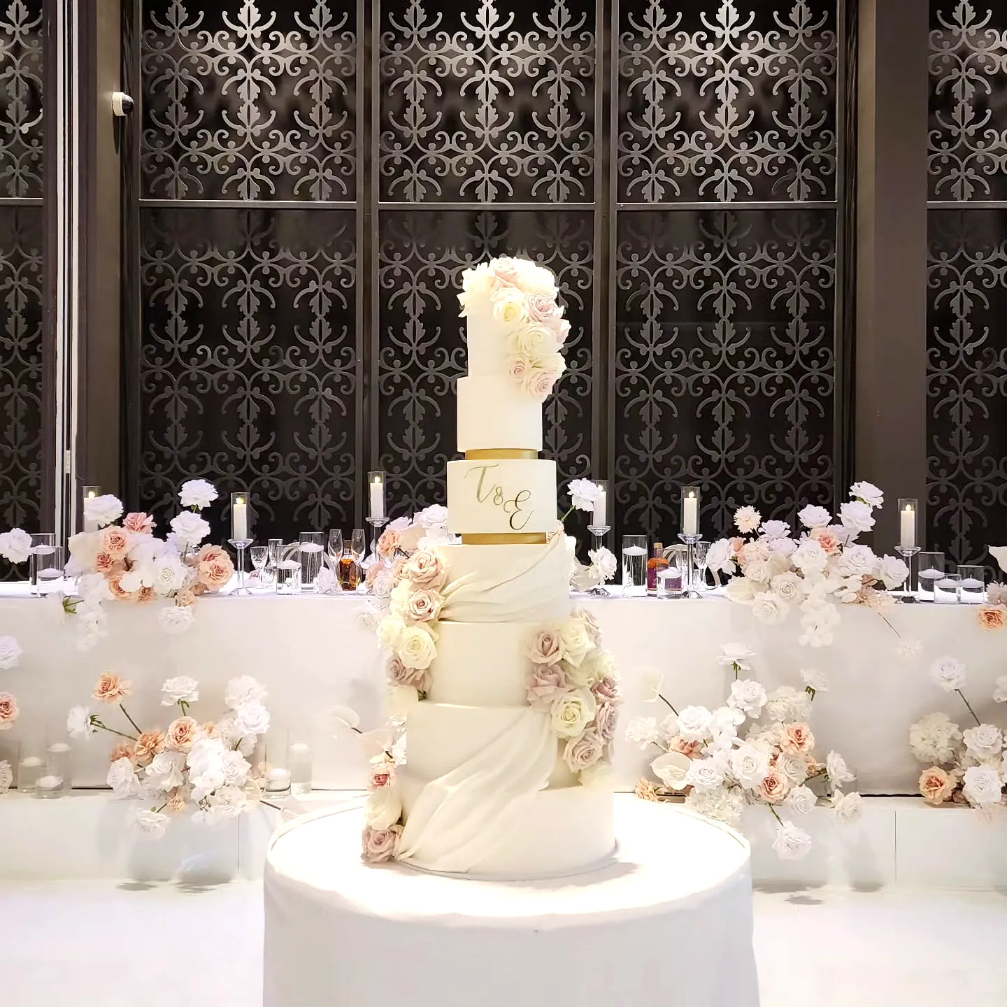 Elegant Wedding Cake with Cascading Roses and Gold Love Sign
