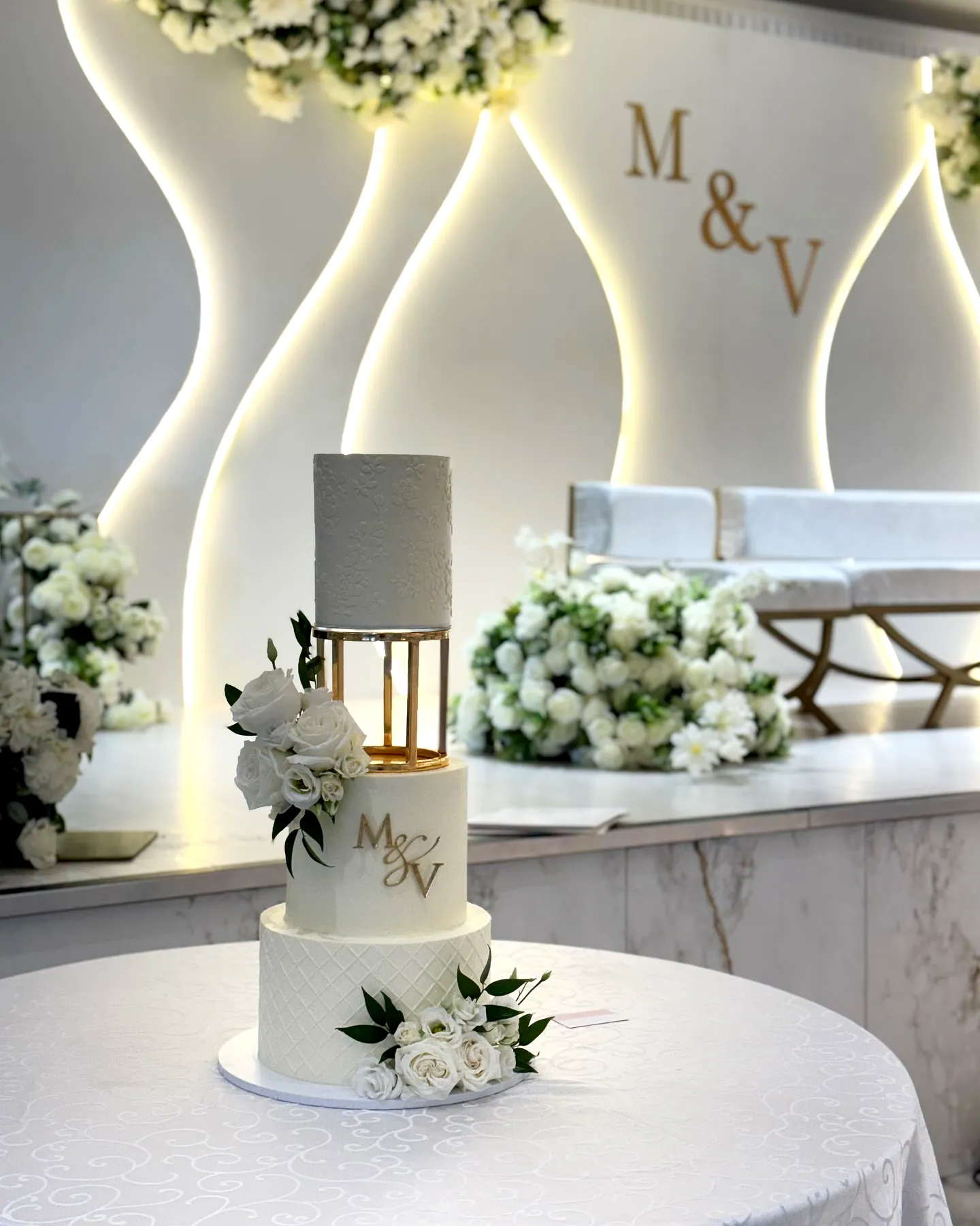 Elegant white wedding cake design with floral accents and personalized details