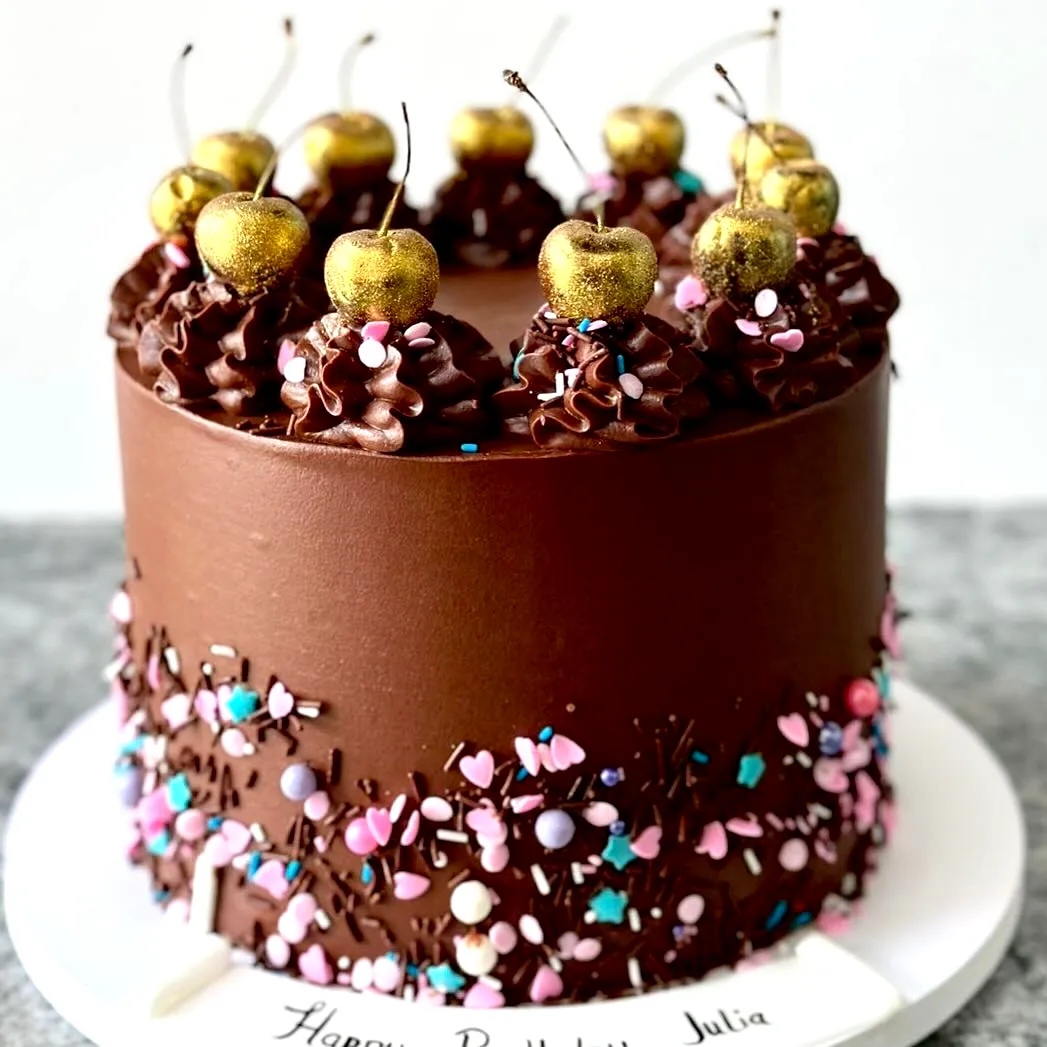Festive Chocolate Birthday Cake with Gold-Dusted Cherries and Colorful Sprinkles