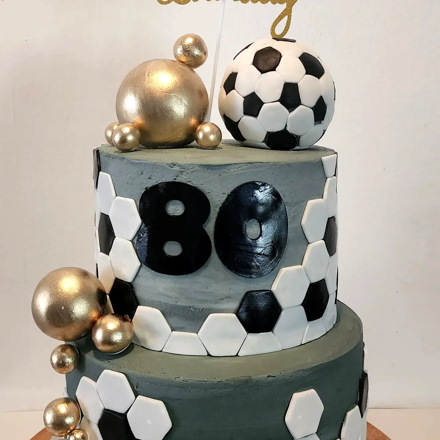Fun soccer-themed 80th birthday cake design with textured gray frosting
