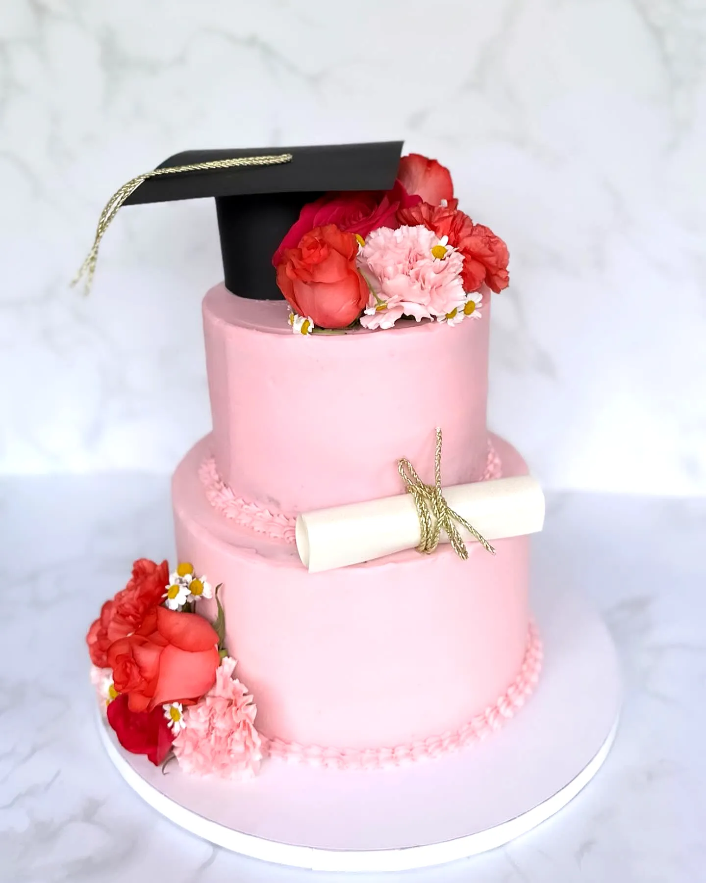Lovely 2 Tier Graduation Cake Design with Floral Accents and Celebratory Touches