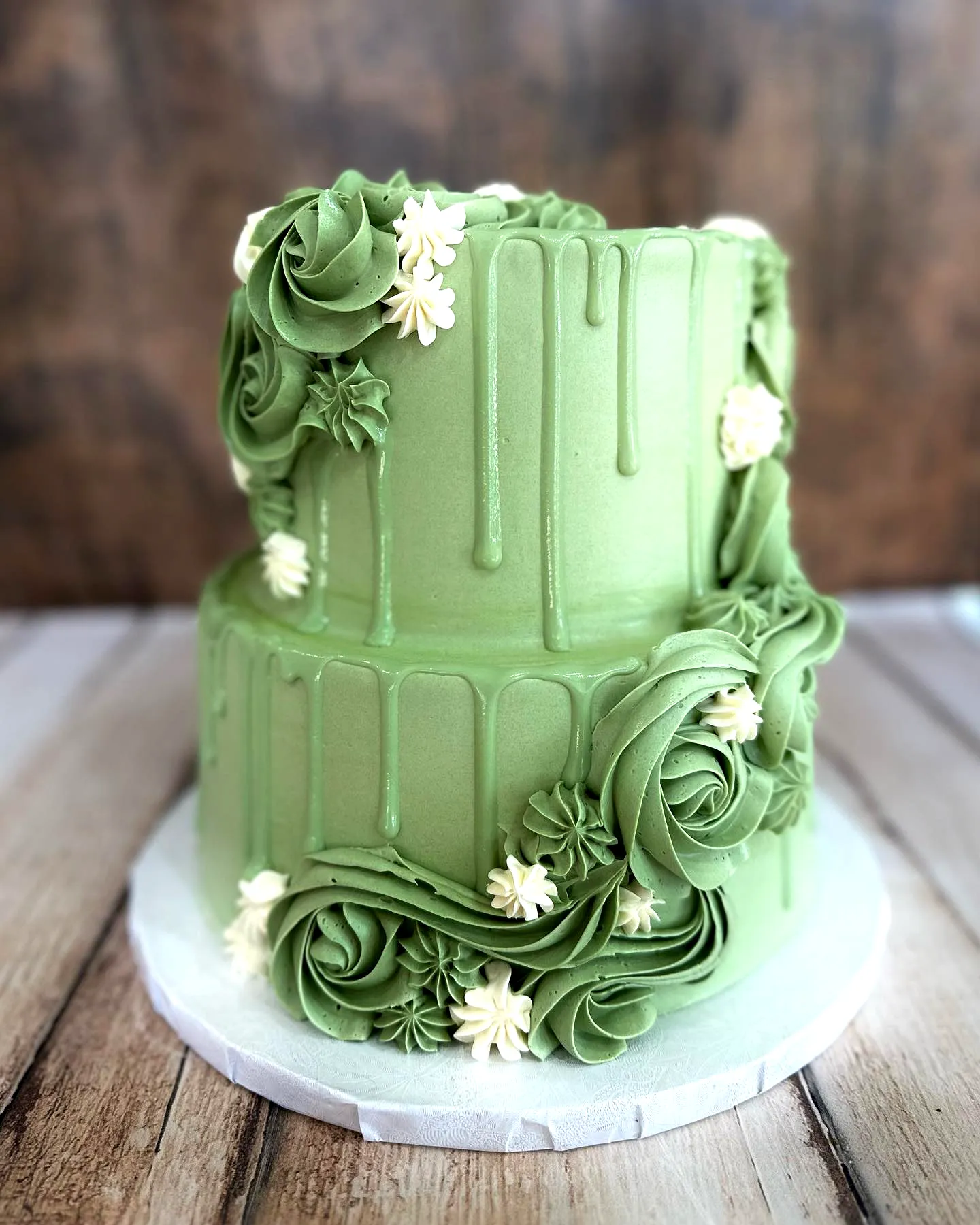 Lovely green birthday cake design with elegant rosettes and a modern drip effect