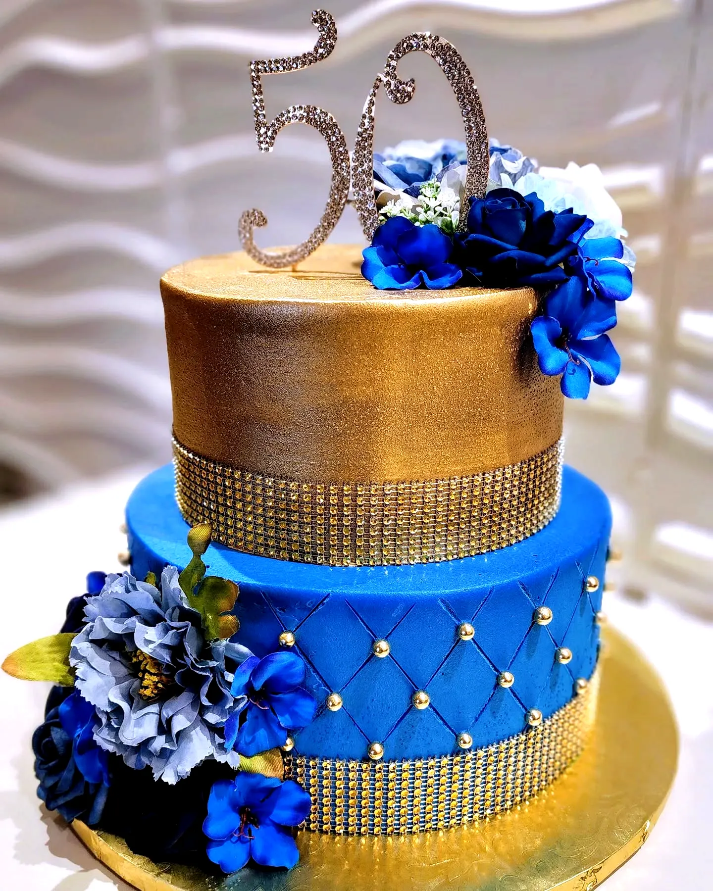 Stunning 50th birthday cake design in gold and blue with elegant details