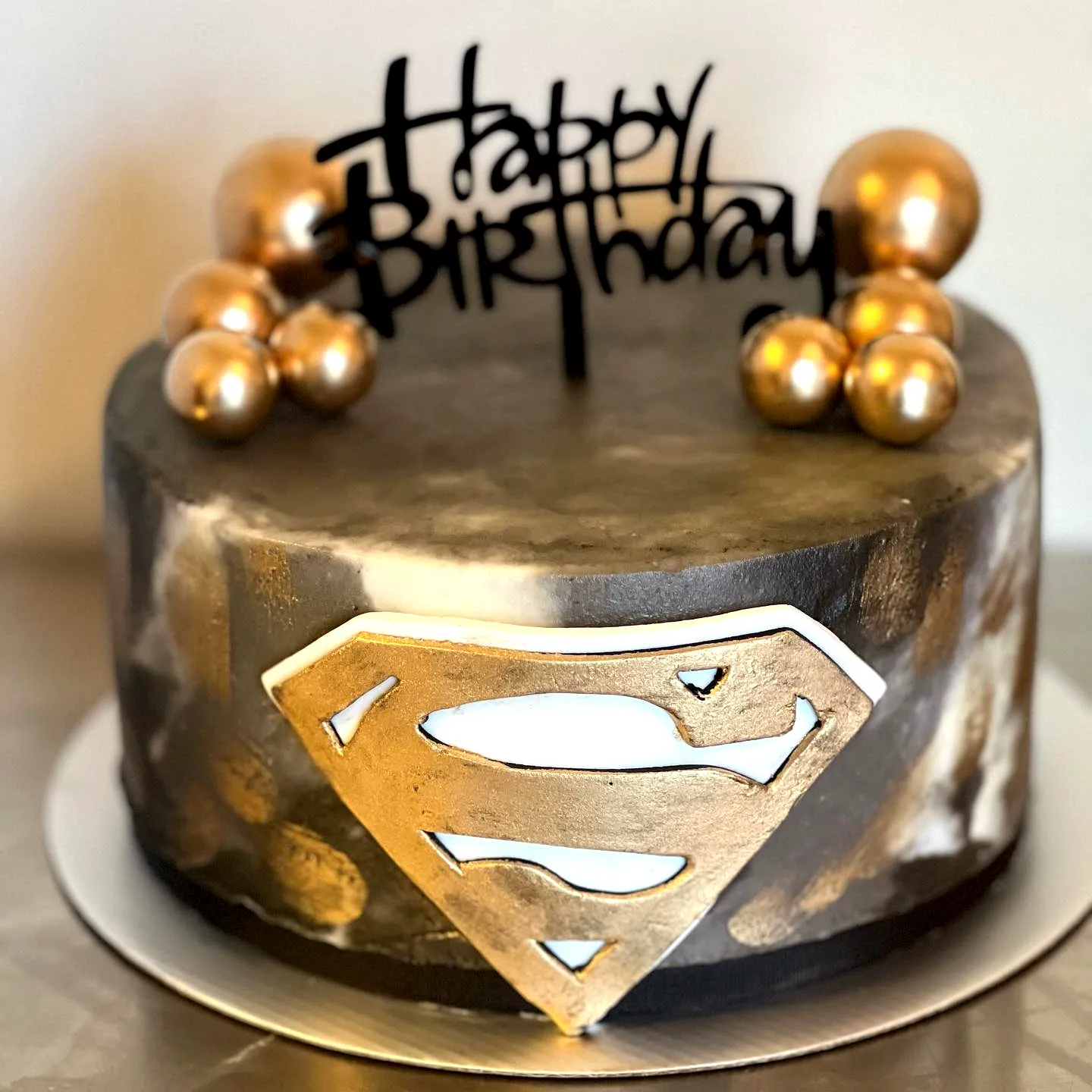 Trendy Chocolate Cake for Adults with Black and Gold Superman Design