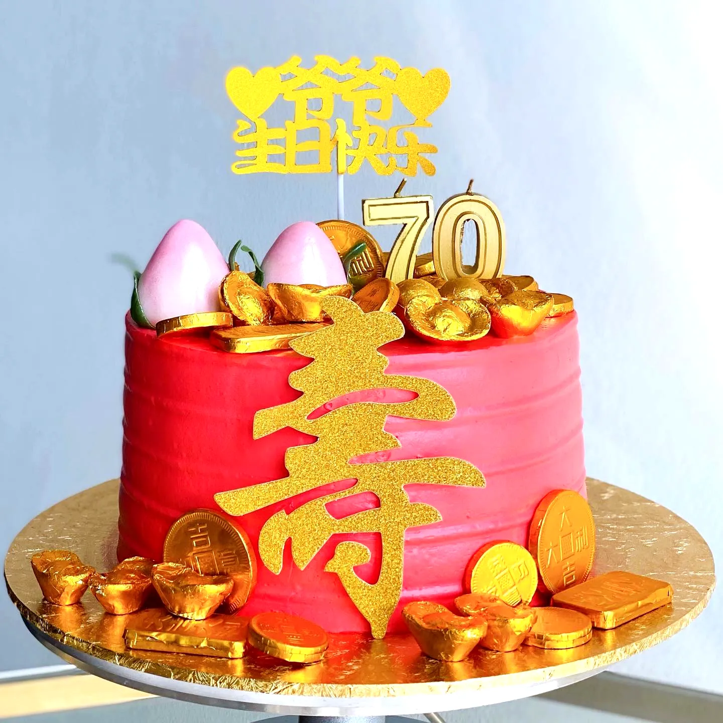 Vibrant Pink 70th Birthday Cake with Gold Accents and Festive Decor